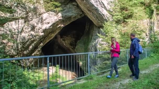 Push Couple Pausing Bridge Look Cave Rock Formation — Vídeos de Stock