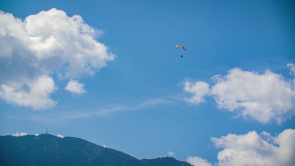 Parapente Voando Contra Céu Azul Nublado Com Montanha Florestada Fundo — Vídeo de Stock