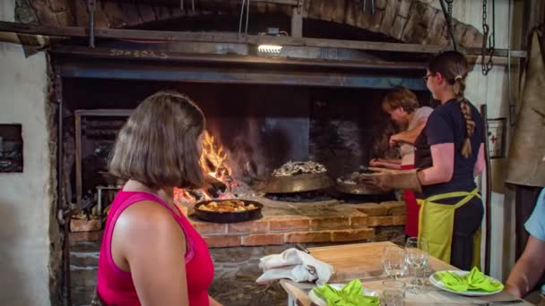 Dwie Kobiety Wyjmują Żeliwną Patelnię Pieca Opalanego Drewnem Podać Obiad — Wideo stockowe