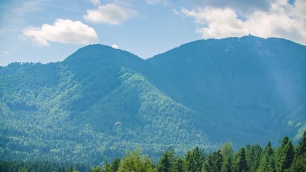 パラグライダーは 高いピックUrslja Gora Kotlje スロベニアで丘陵地を飛ぶ — ストック動画