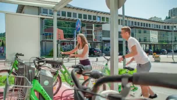 Dos Jóvenes Turistas Bajándose Las Bicicletas Alquiler Dejándolos Estación Después — Vídeos de Stock