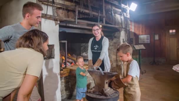 Blacksmith Işini Öğrendikten Sonra Oğullarının Eldivenlerini Çıkarmasını Izleyen Ebeveynler — Stok video