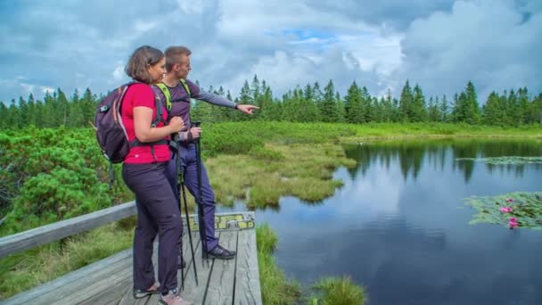 Dos Excursionistas Mirando Lago Conversando — Vídeo de stock