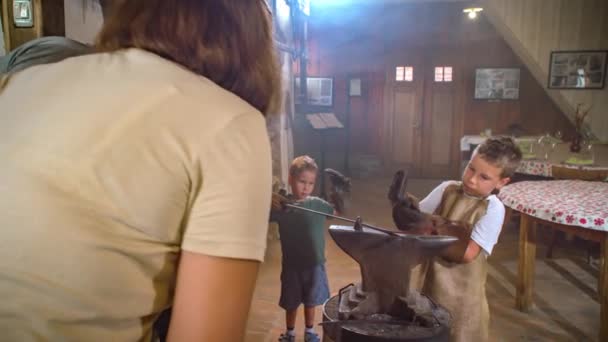 Ailesi Onu Izlerken Bir Çocuğun Kızgın Demir Parçasını Çekiçle Çekiçlemesi — Stok video