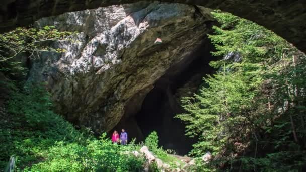 巨大な洞窟から2人のハイカーの傾きのショット — ストック動画