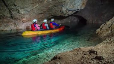 Mezica 'nın Glancnik kentindeki eski tarihi madendeki yeraltı kanosunun tadını çıkaran turistler. Düşük açı, ön görünüm.