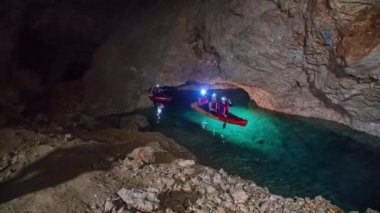 Mezica 'nın Glancnik kentindeki eski tarihi madendeki yeraltı kanosunun tadını çıkaran turistler. Düşük açı, ön görünüm.