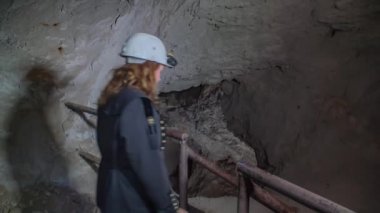 Tur grubu Glancnik, Mezica, Slovenya 'daki karanlık maden tünellerinde yürüyor