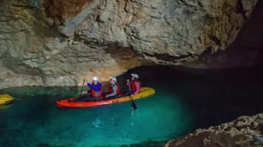Mezica 'nın Glancnik kentindeki eski tarihi madendeki yeraltı kanosunun tadını çıkaran turistler. Düşük açı, ön görünüm.