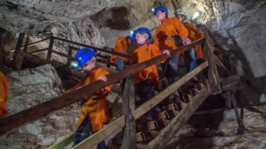 Slovenya Mezica Maden Turu 'nda merdivenlerden inen bir grup ziyaretçi