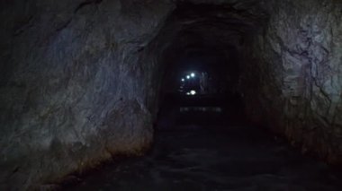 Mezica 'nın Glancnik kentindeki eski tarihi madendeki yeraltı kanosunun tadını çıkaran turistler. Düşük açı, ön görünüm.