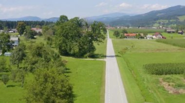 Slovenya 'nın traktör, evler, çiftlikler ve aşağıdaki karayollarıyla Slovenya' daki Slovenya Gradec kasabasının hava manzarası, İHA kulesi görüntü, plaka ve traktör operatörü bulanıklaştı.