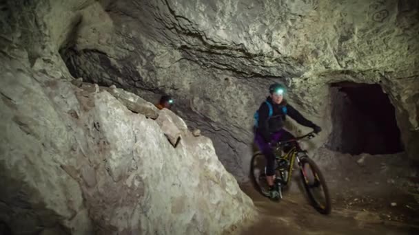 Άνθρωποι Mountain Bike Προς Την Κάμερα Μια Υπόγεια Σπηλιά Αργή — Αρχείο Βίντεο