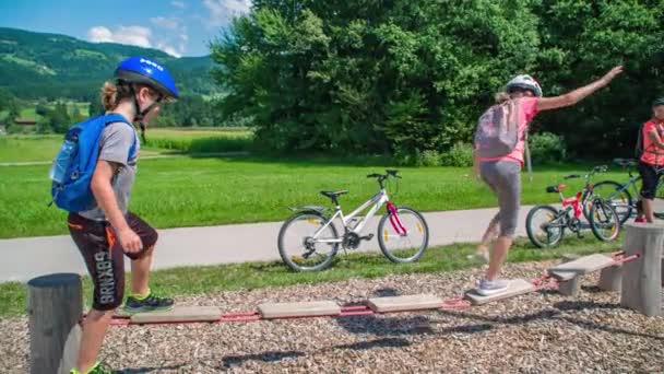 男の子と女の子は小さな出口遊び場でバランスボードをプレイ — ストック動画