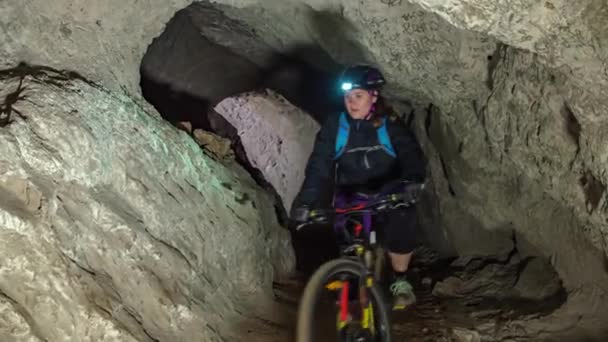一群女人们骑着自行车进入一个黑暗的矿山洞穴 一个与朋友一起冒险的洞穴 — 图库视频影像