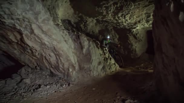 Dwóch Chłopców Jeżdżących Rowerach Górskich Wewnątrz Tunelu Górniczego Pod Górą — Wideo stockowe