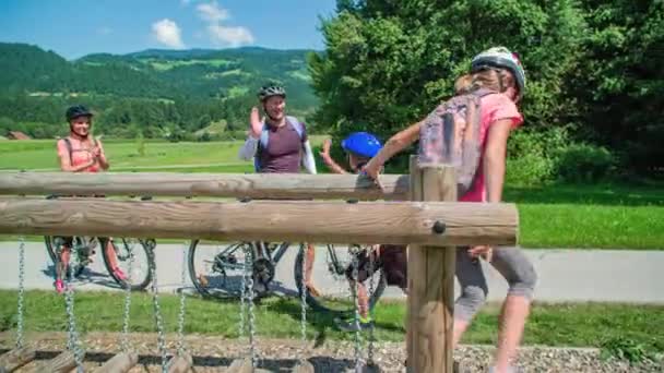 子供たちは障害物を越えて走る 親は子供に高い5を与える 家族はサイクリングを続ける スロベニア グラデツ — ストック動画