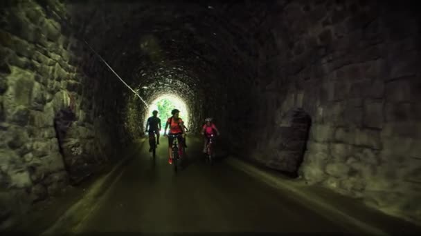 スロベニアの有名なサイクリングパスであるストレンカのトンネルに沿って自転車に乗っている子供たちの家族 — ストック動画