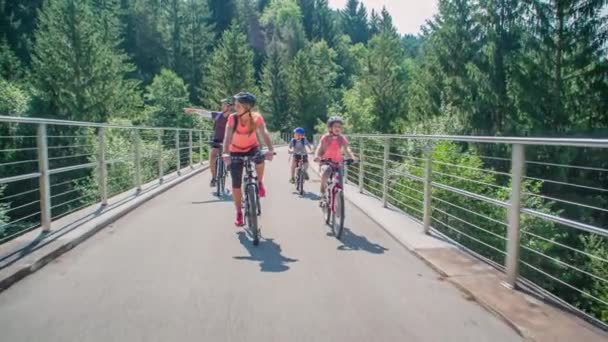 Långsam Rörelse Familj Ridning Cyklar Bland Träd Förhöjd Väg Strekna — Stockvideo