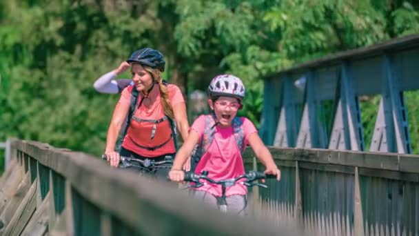 古い素朴な橋の上で保護具で家族 親と子供 サイクリングし 景色を楽しむ — ストック動画