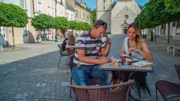 若いカップルはスロベニアのGradec市内のバーテーブルで朝食を取ることができます スロベニア — ストック動画