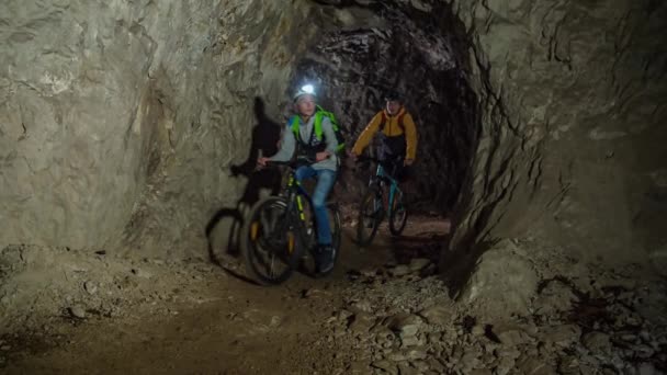 スロベニアのメジカで自転車と地下鉱山トンネルを探索する家族のスローモーション — ストック動画