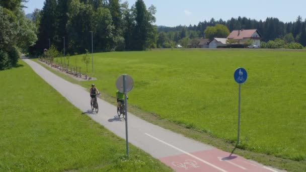 Мужчина Женщина Едут Велосипеде Дороге Проезжая Мимо Знака Воздушный Дрон — стоковое видео