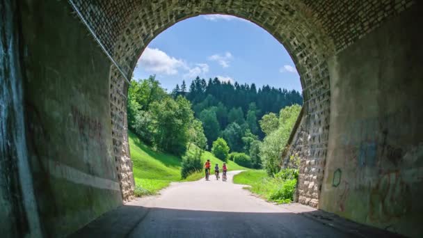 Slow Motion Familj Ridning Cyklar Mot Tunnel Strekna Vacker Väg — Stockvideo