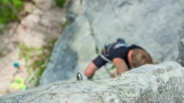 Genç maceraperest dağcı, kaya tırmanışının aşırı sporundan zevk alıyor. Macera ve ekstrem spor anlayışı. Yukarıdan görüntüle.