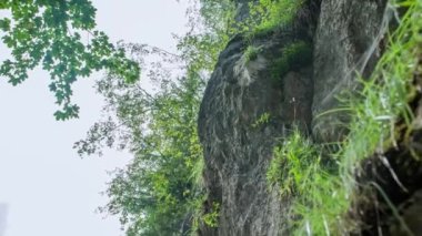 Beyaz bir adamın dağa tırmanırken düşük açılı görüntüsü. Yavaş çekim