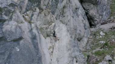 İleri giden hava aracı görüntüleri bir dağcının dik ve kayalık dağlık araziyi geçtiğini gösteriyor. Macera ve ekstrem spor kavramı..