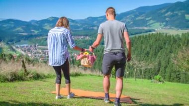 Genç romantik çift piknik sepetiyle yürüyor. Sevgililer Günü 'nü kutlayalım.