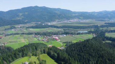 Aşağıdaki Sveti Vid ve Zgornja Vizinga kasabaları, Drava nehri ve tarım arazileri ile Slovenya kırsalının hava üssü yavaş ilerliyor.