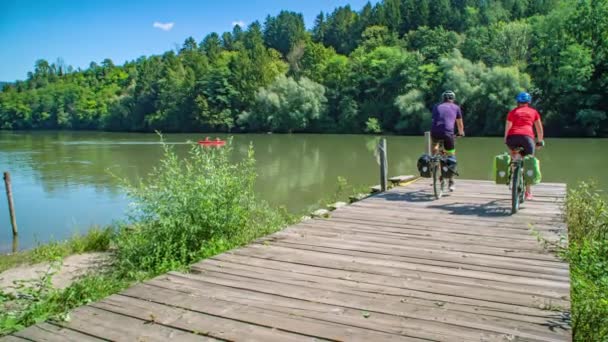 カップルはドックで自転車を止め 川のカヌーの人々で波 スローモーション — ストック動画