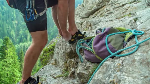 Hombre Arregla Zapatos Escalada Roca Pie Cornisa Alta Montaña Cerca — Vídeo de stock