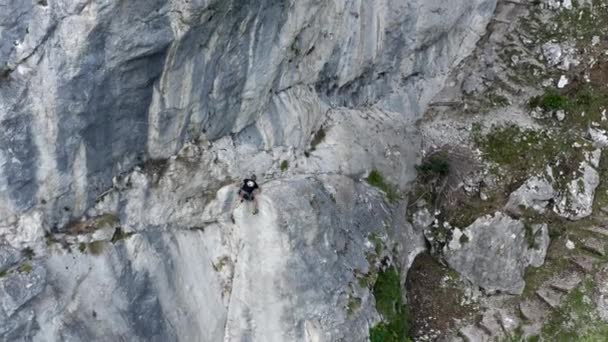 空中无人驾驶飞机拍摄到一个登山者穿过陡峭岩石的山地 冒险和极限运动的概念 — 图库视频影像