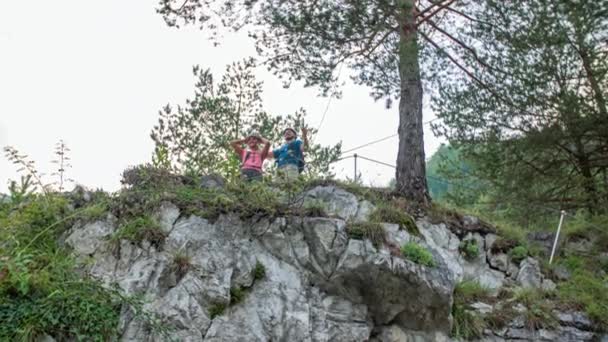 クライミングギアの若いカップルは丘を登ることを祝う — ストック動画