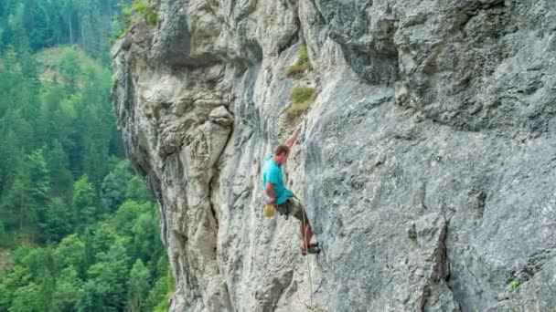 年轻英俊的攀岩者到达粉笔袋 Burjakove Peci 极限运动 — 图库视频影像