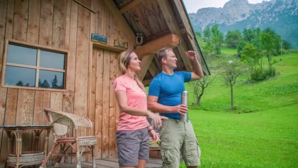 Young Couple Standing Together Front Charming Wood Cabin Looking Out — Stock Video
