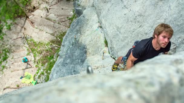 极限运动 年轻强壮英俊的男子带着安全装置爬上垂直的岩石 — 图库视频影像