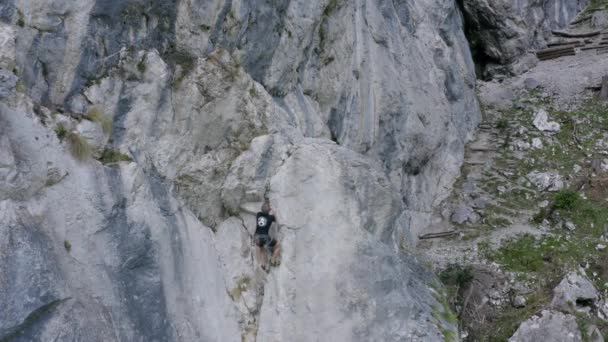 一个登山者穿越陡峭岩石的山地的空中镜头 冒险和极限运动的概念 — 图库视频影像