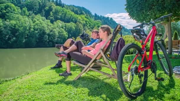 Ontspannen Jong Paar Zitten Aan Rivier Het Fietsen Zwaaien Naar — Stockvideo