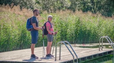 Kafkas yürüyüşçüleri Idyllic Pond 'daki olay yerini işaret ediyor. Radje ob Dravi, Slovenya
