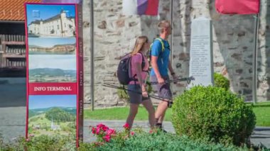 Genç ve neşeli bir çift kilisenin yakınındaki Dravograd 'ın turistik kasabasında yürüyor.