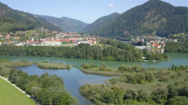 Dravograd Gölü ve yuvarlanan dağları çevreleyen yemyeşil bitki örtüsü