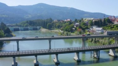 Erkek ve kadın bisikletçilerin Drava üzerinde her iki yönde de köprü boyunca bisiklet sürerken hava görüntüsü, İHA tarafı sol hareketi izliyor
