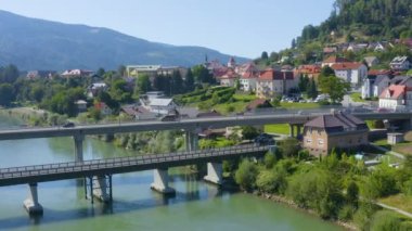 Erkek ve kadının Drava nehri üzerindeki bir köprü boyunca bisiklet sürerken çekilmiş hava görüntüsü, İHA tarafı sol hareketi izliyor.