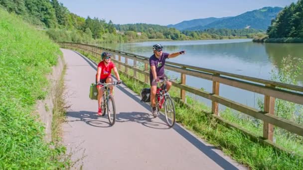 Feliz Casal Ciclismo Longo Rio Apreciando Montanhas Alpinas Vista Ensolarada — Vídeo de Stock