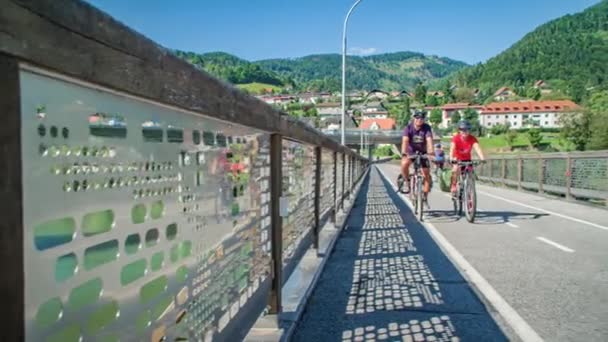 Lyckligt Par Cykling Över Bro Berg Bakgrunden Slovenj Gradec — Stockvideo