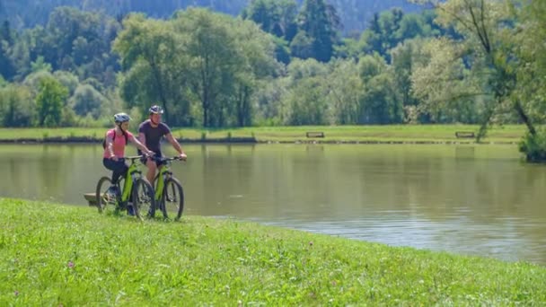 Kilku Podróżnych Jeżdżących Rowerach Górskich Wzdłuż Pięknego Jeziora Łabędziami Słowenii — Wideo stockowe